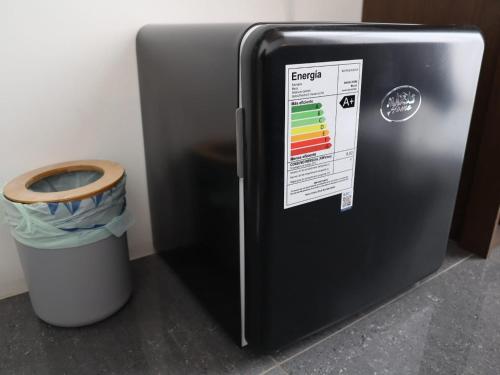 a black refrigerator with a trash can next to it at Hostal Litoral in Iquique