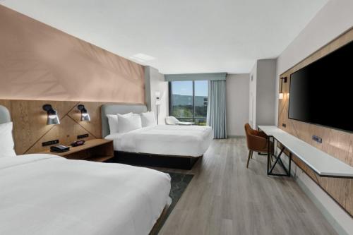 ヒューストンにあるHouston Marriott Northのベッド2台、薄型テレビが備わるホテルルームです。