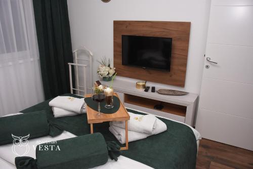 a living room with a couch and a tv at VESTA Apartman in Sremska Mitrovica