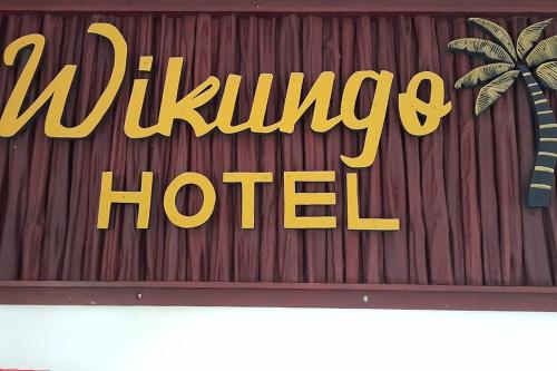 una señal para un hotel con una palmera en Wikungo Hotel en Puerto Nariño