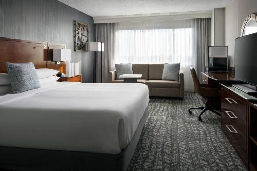 una camera d'albergo con un grande letto e un divano di Bakersfield Marriott at the Convention Center a Bakersfield