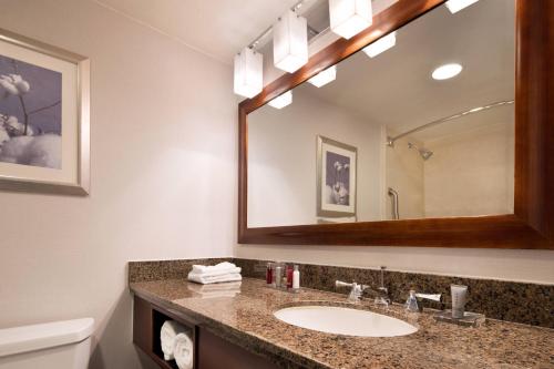 a bathroom with a sink and a mirror at Bakersfield Marriott at the Convention Center in Bakersfield