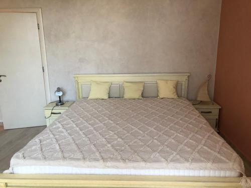 a bedroom with a large bed with two night stands at Морска Роза in Sinemorets