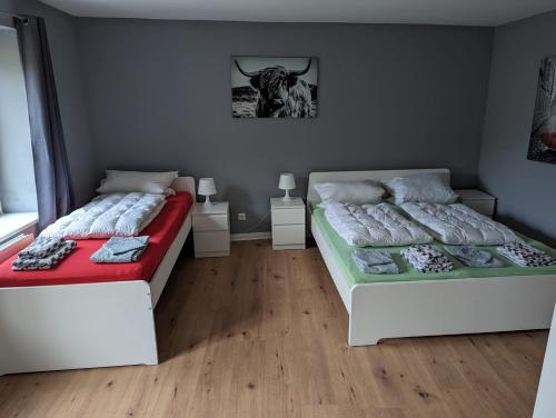 a bedroom with two beds and a cow picture on the wall at Flensburg Zentrum 69 01 in Flensburg