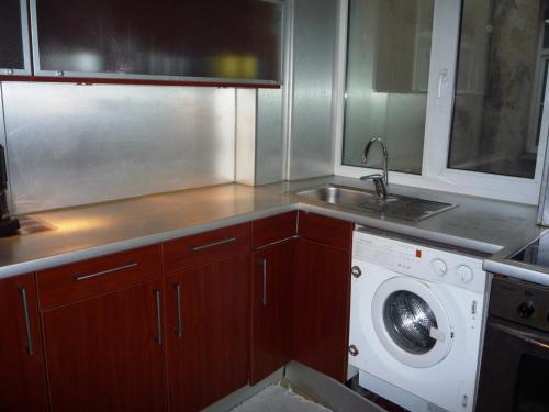 a kitchen with a washing machine and a sink at Home Sweet Home in Rīga