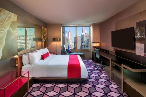 a hotel room with a bed and a flat screen tv at W New York - Times Square in New York