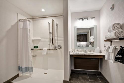 baño blanco con ducha y lavamanos en TownePlace Suites by Marriott Bridgewater Branchburg, en Branchburg Park