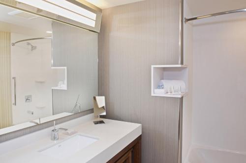 a bathroom with a white sink and a mirror at Courtyard by Marriott Seattle Everett Downtown in Everett