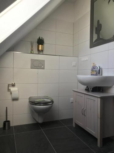 a white bathroom with a sink and a toilet at Monteurzimmer Ostalb in Lauchheim