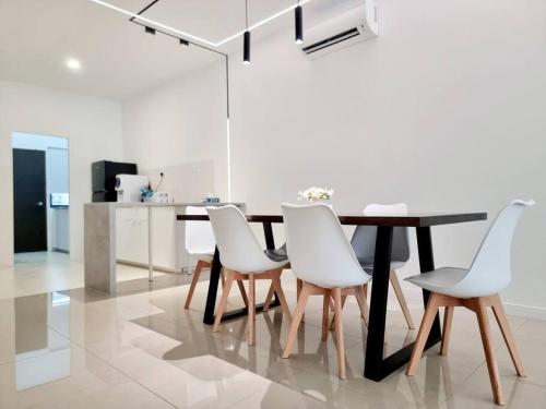 uma sala de jantar com uma mesa e cadeiras brancas em H+M Residence [5min]to Setia City Convention em Shah Alam