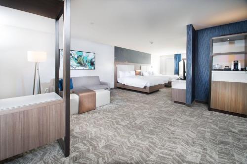 a hotel room with two beds and a bathroom at SpringHill Suites by Marriott Fayetteville Fort Liberty in Fayetteville