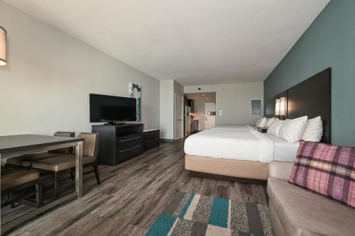 a hotel room with a bed and a desk and a television at Residence Inn by Marriott Myrtle Beach Oceanfront in Myrtle Beach