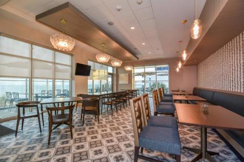 a dining room with tables and chairs and windows at Residence Inn by Marriott Myrtle Beach Oceanfront in Myrtle Beach