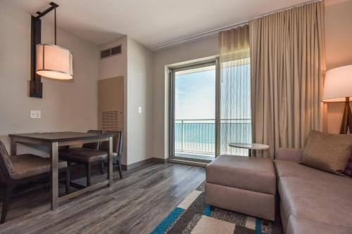 a living room with a couch and a table with a view at Residence Inn by Marriott Myrtle Beach Oceanfront in Myrtle Beach