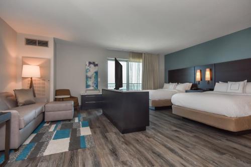 マートルビーチにあるResidence Inn by Marriott Myrtle Beach Oceanfrontのベッド2台とソファが備わるホテルルームです。