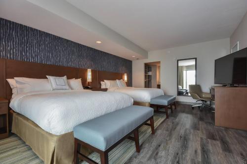 a hotel room with two beds and a flat screen tv at Residence Inn by Marriott Myrtle Beach Oceanfront in Myrtle Beach