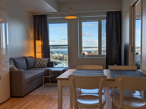 uma sala de estar com uma mesa e um sofá em City Apartment with lake view and free parking em Kuopio