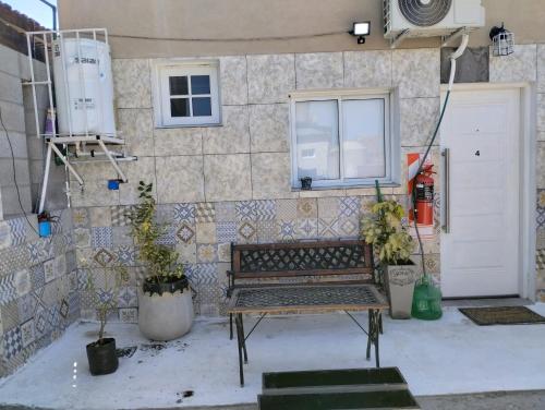 a bench in front of a building with a window at Lu-Mar in Comodoro Rivadavia