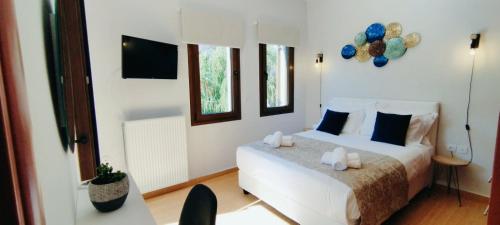 a bedroom with a white bed with blue pillows at "IRO HOUSE" 600m from the beach in Gerani