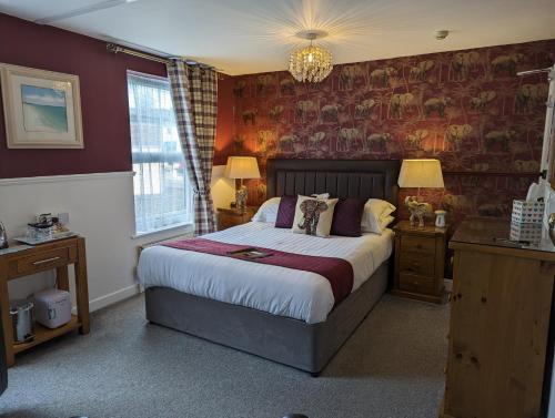a bedroom with a large bed with red walls at Abingdon House in Torquay