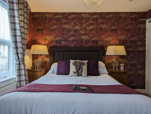 a bedroom with a large bed with two lamps at Abingdon House in Torquay