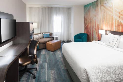 Habitación de hotel con cama y escritorio con TV. en Courtyard by Marriott Fort Worth Historic Stockyards, en Fort Worth