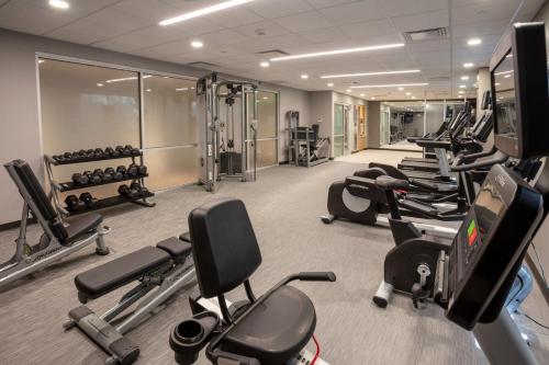 a gym with a row of treadmills and machines at Courtyard Rochester Downtown in Rochester