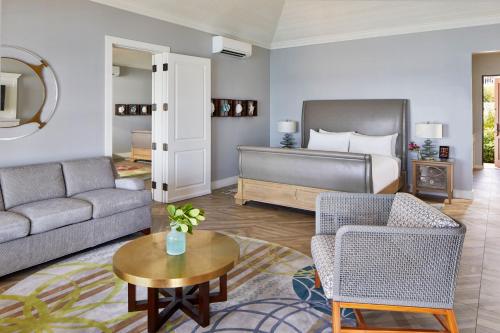 a living room with a couch and a bed at French Leave Resort, Autograph Collection in Governorʼs Harbour