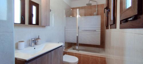 a bathroom with a toilet and a sink and a shower at "IRO HOUSE" 600m from the beach in Gerani