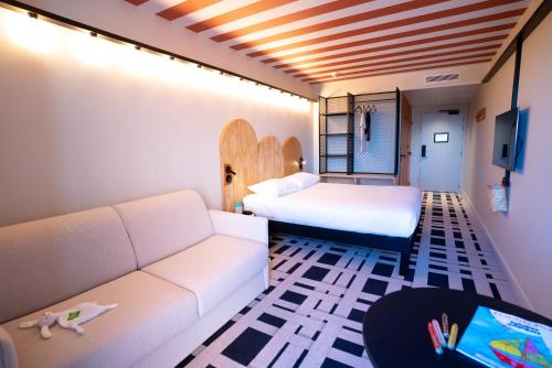 a living room with a couch and a bed at ibis Styles Montauban in Montauban