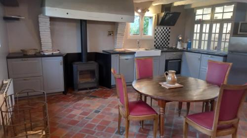 une cuisine avec une table, des chaises et une cuisinière dans l'établissement le havre de paix, à Devay