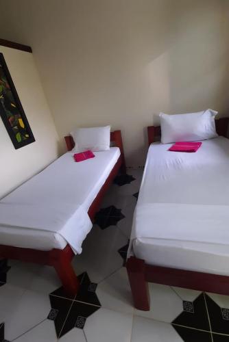 two beds sitting next to each other in a room at Wikungo Hotel in Puerto Nariño