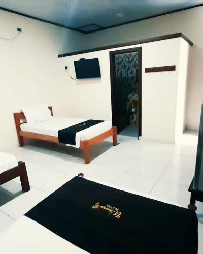 a bedroom with a bed and a black rug at Wikungo Hotel in Puerto Nariño