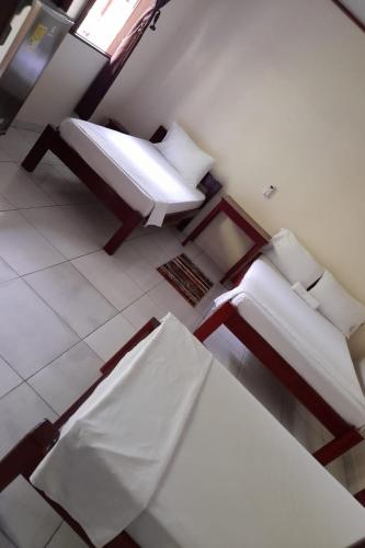a room with two beds and a table and a window at Wikungo Hotel in Puerto Nariño
