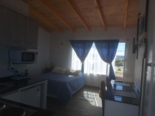 Habitación pequeña con cama y ventana en Lu-Mar en Comodoro Rivadavia