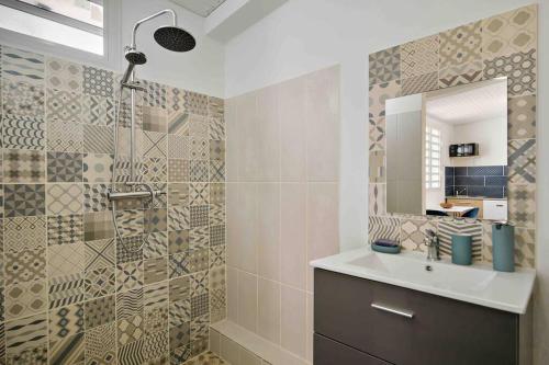La salle de bains est pourvue d'un lavabo et d'un miroir. dans l'établissement Le Camélia - Gîte "Terre et Truffes", au Lamentin