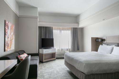 Habitación de hotel con cama y TV en SpringHill Suites by Marriott Cheyenne en Cheyenne