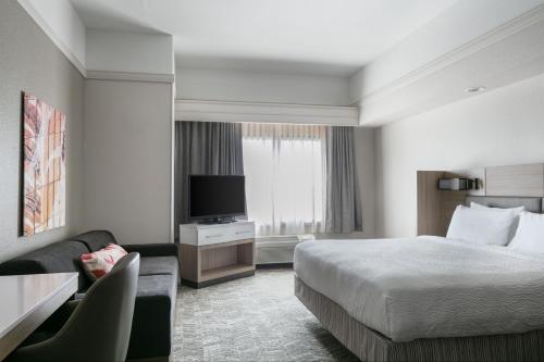 a hotel room with a bed and a television at SpringHill Suites by Marriott Cheyenne in Cheyenne