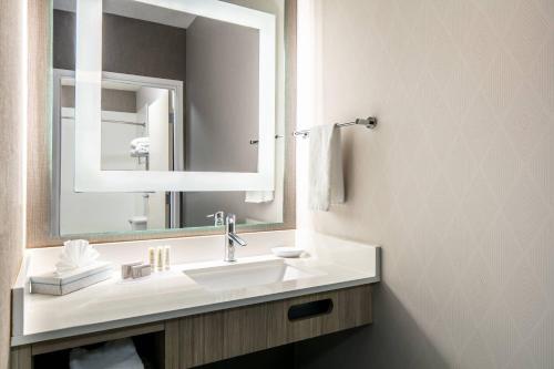La salle de bains est pourvue d'un lavabo et d'un miroir. dans l'établissement SpringHill Suites by Marriott Tulsa, à Tulsa