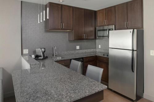 a kitchen with a stainless steel refrigerator and wooden cabinets at Residence Inn by Marriott Orangeburg in Orangeburg