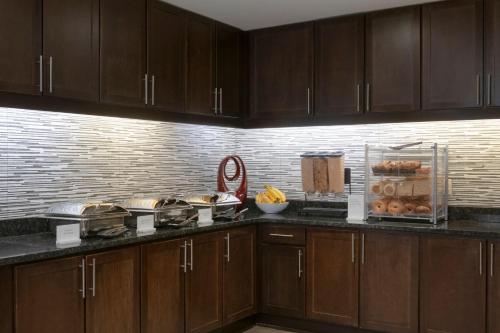 a kitchen with wooden cabinets and a counter top at Residence Inn by Marriott Orangeburg in Orangeburg