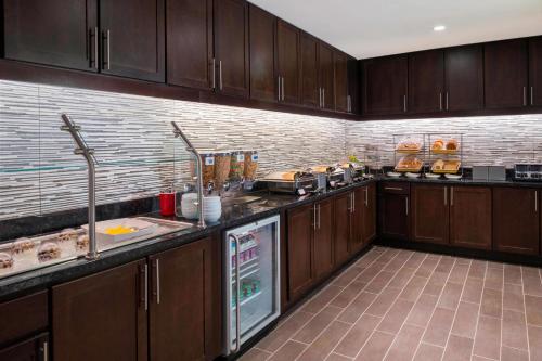 a large kitchen with wooden cabinets and appliances at Residence Inn by Marriott Orangeburg in Orangeburg