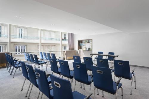 an empty room with blue chairs and a table at Le Meridien Nice in Nice