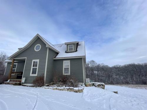 una casa verde con nieve en el suelo en Gorgeous cabin 3bdrm/3bth, hot tub, fireplace, kid/pet friendly en Galena