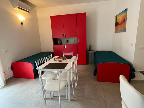 een kamer met rode kasten en een tafel en stoelen bij Un balcone sul mare in Gallipoli