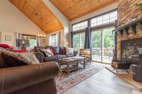 a living room with a couch and a fireplace at Gorgeous cabin 3bdrm/3bth, hot tub, fireplace, kid/pet friendly in Galena