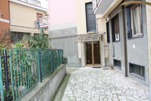 a stone walkway in front of a building with a gate at Casa Emma 400 mt dal mare in Spotorno