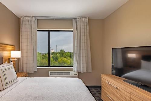 um quarto com uma grande janela e uma televisão em TownePlace Suites by Marriott Dallas Mesquite em Mesquite