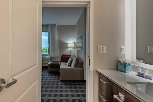 TownePlace Suites by Marriott Dallas Mesquite في ميسكوايت: غرفة مع غرفة معيشة مع أريكة
