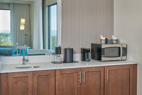 a kitchen counter with a microwave and a sink at Courtyard by Marriott Petoskey at Victories Square in Petoskey